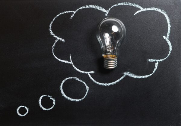 A light bulb inside a chalk-drawn thought bubble on a blackboard.